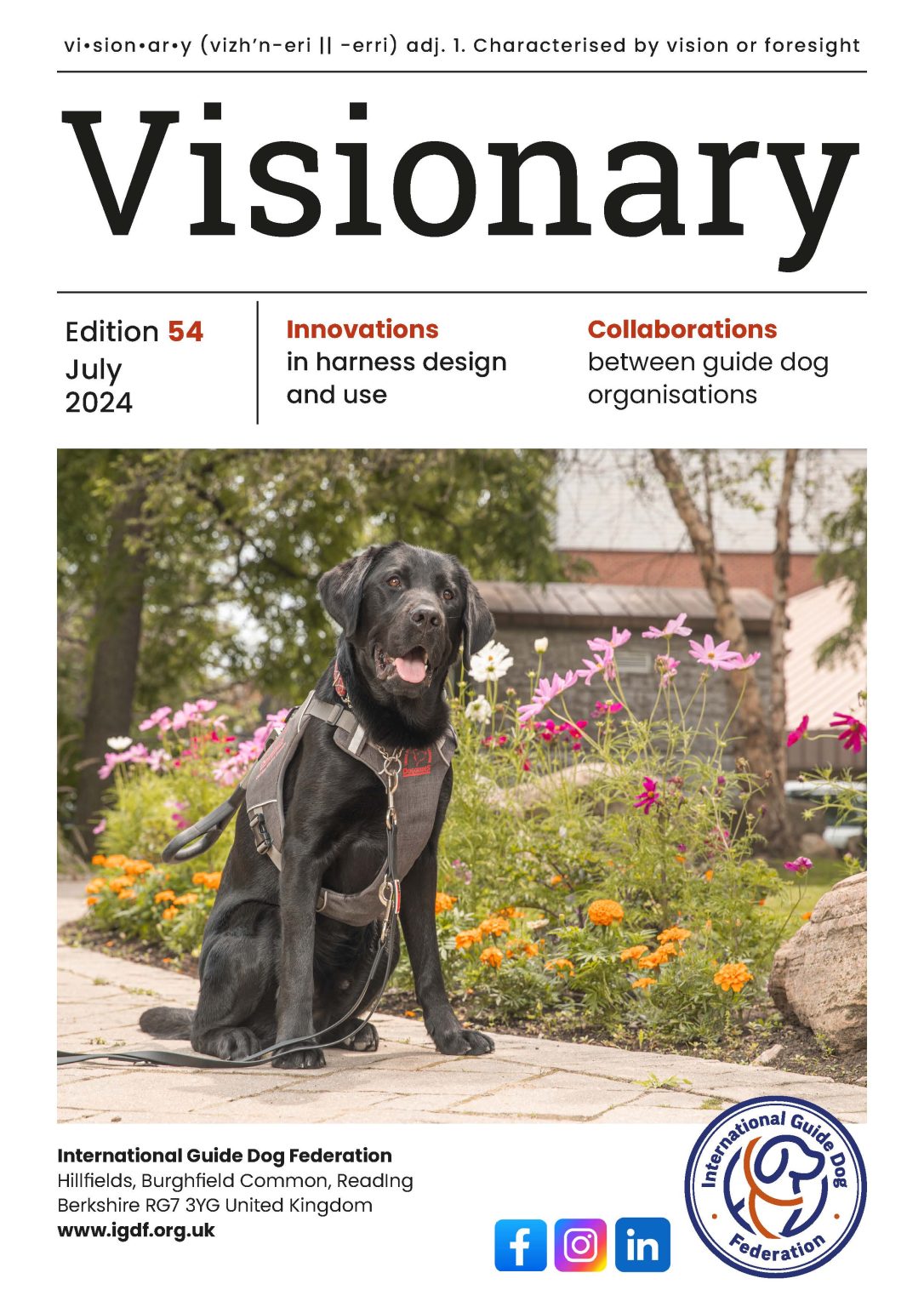 Cover page of Visionary Magazine featuring a Black Lab sitting infront of a flower bed